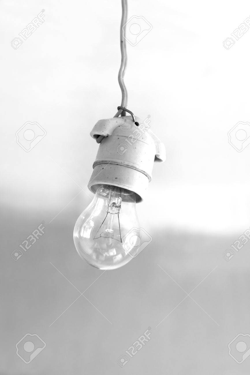 Turning Off An Electric Light Bulb In Ceramic Holder Hanging Stock Stock Photo Turning Off An Electric Light Bulb In Ceramic Holder Hanging On Wire Close Up