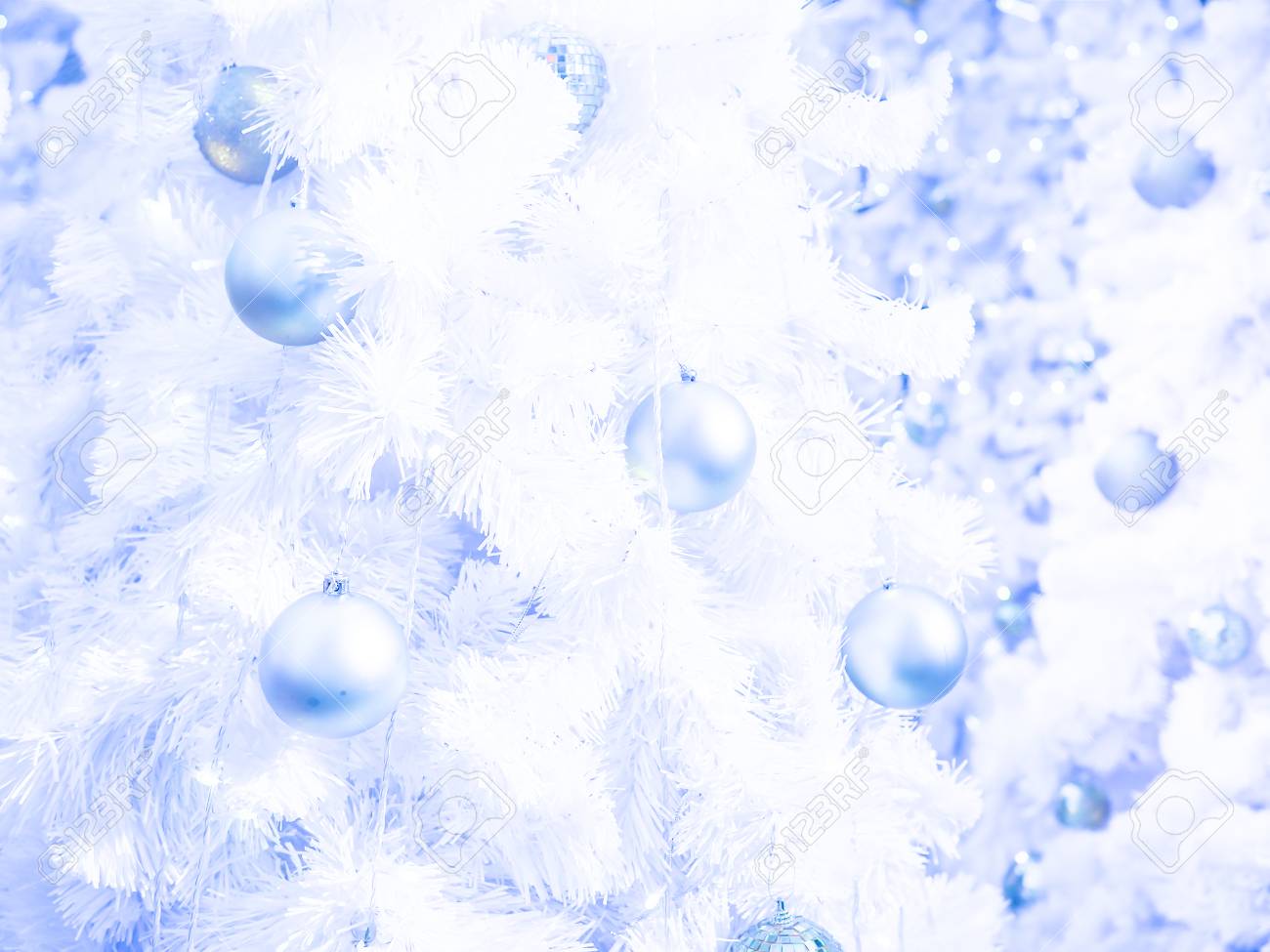 クリスマスの壁紙のための青いトーンで白いクリスマスツリーの背景にスライバーガラスボール の写真素材 画像素材 Image