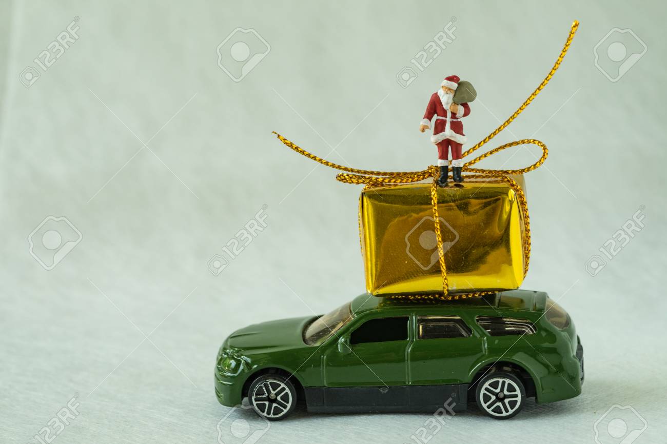 ミニチュアのクリスマスお祝い概念として車の屋根に大きなプレゼント ボックスにサンタ クロースの立っているを図します の写真素材 画像素材 Image