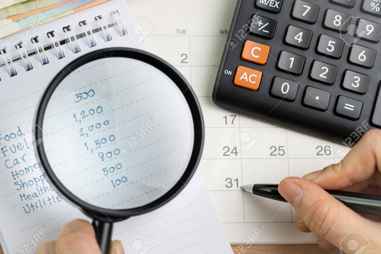personal expense calculation or pay day concept magnifying glass