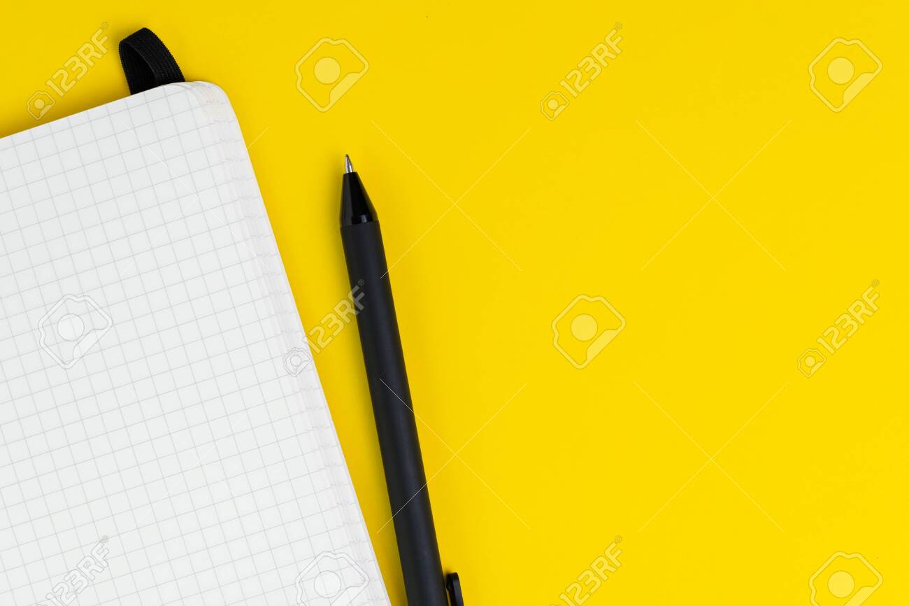 Opening Blank Graph Paper Page Notebook With Pen On Solid Yellow