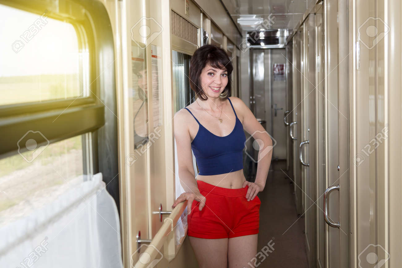 電車パンツ 笑顔のブルネットの女性のショートパンツと動いている電車のタンクトップの廊下。の写真素材・画像素材 Image 180736091