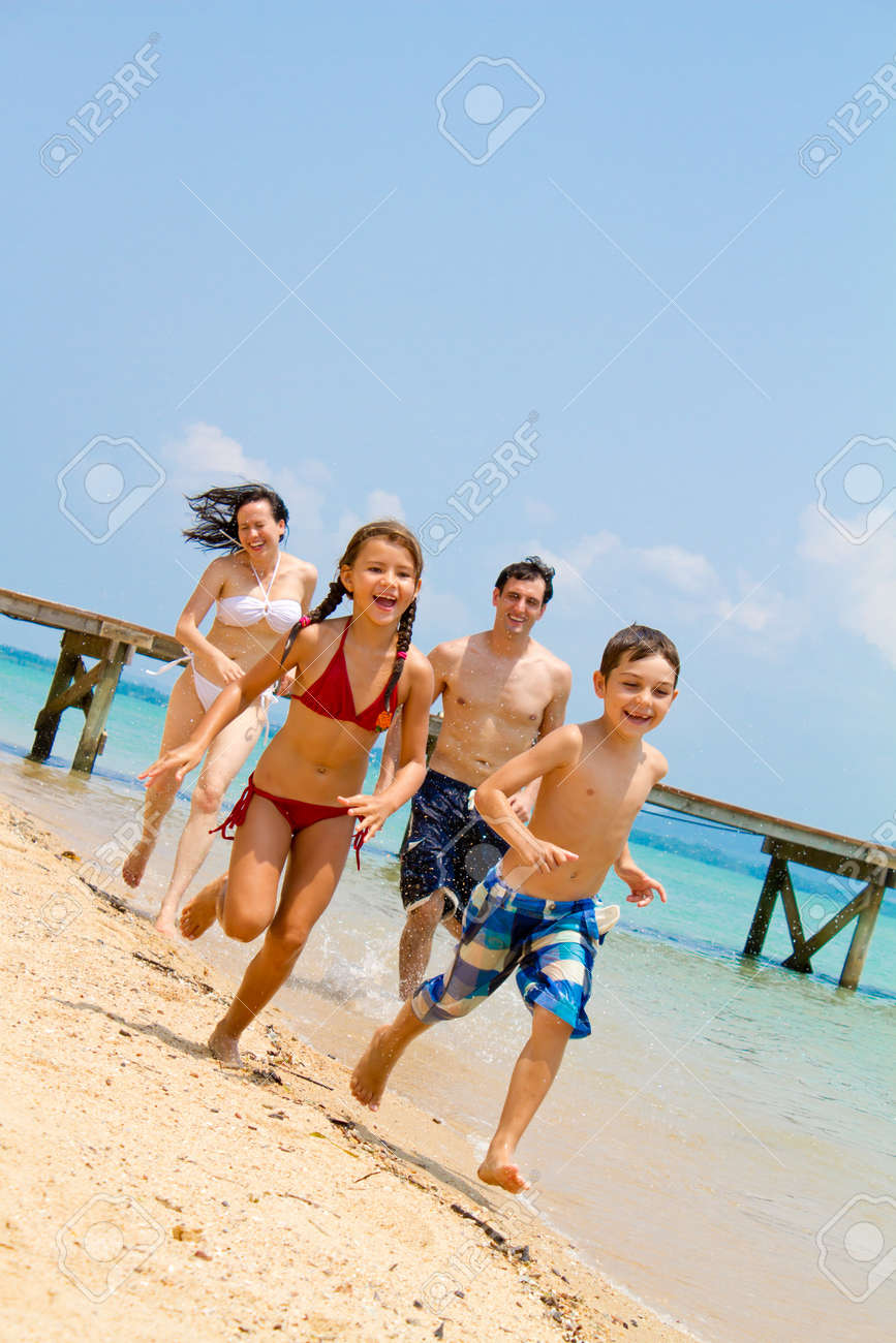 Young family enjoying themselves by the beach - 9919177 Young family enjoying themselves by the beach - 9919177