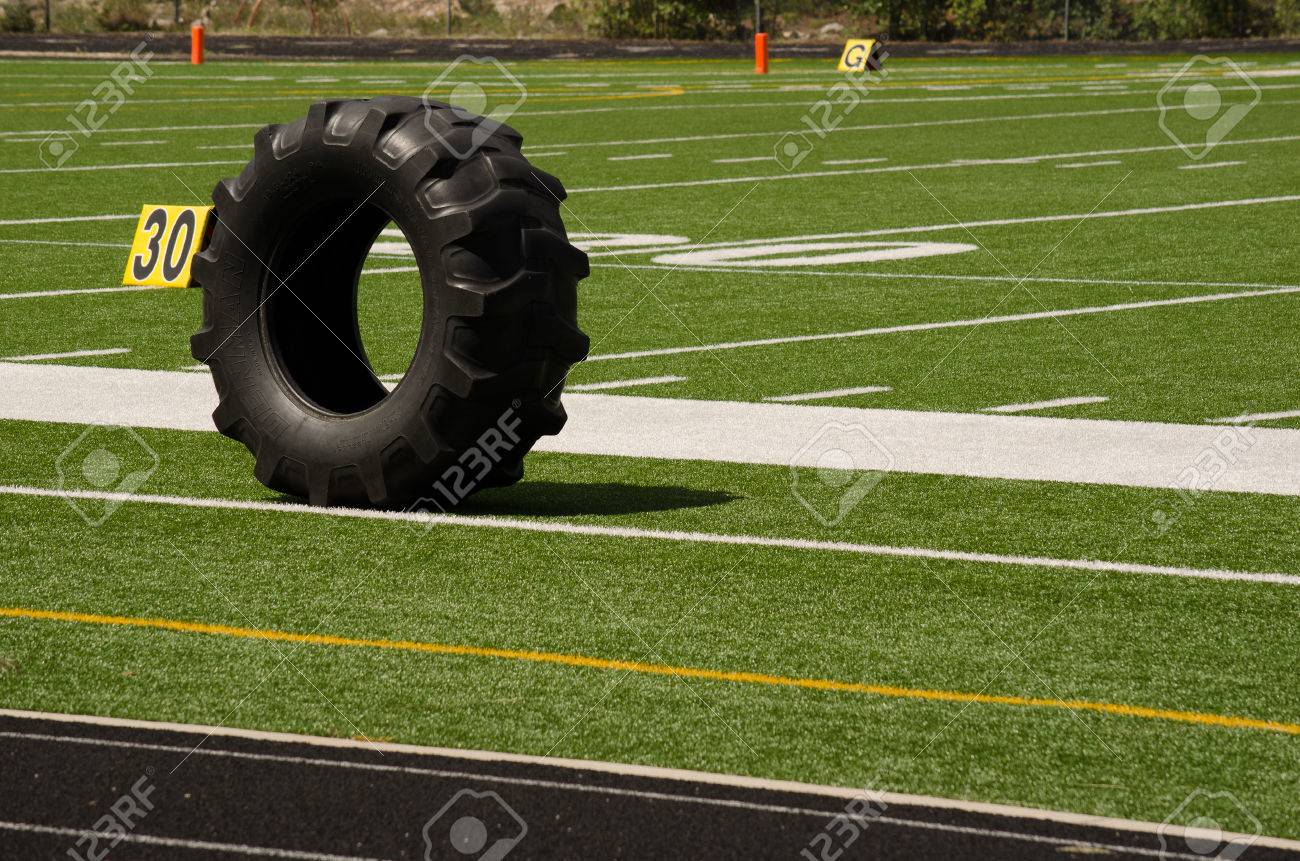 サッカー フィールドのサイドラインに座って代替筋力トレーニング用大型黒トラクター タイヤ の写真素材 画像素材 Image