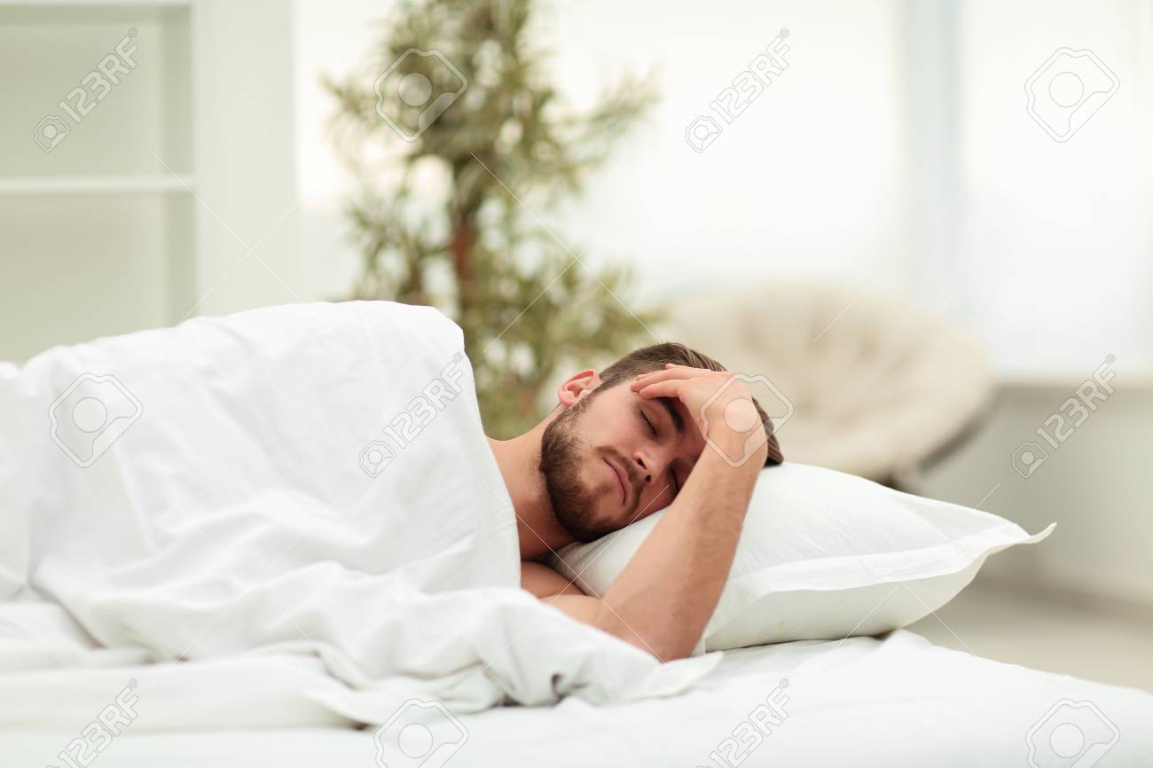 Young Man Is Sleeping In A Comfortable Hotel Room Stock Photo, Picture And Royalty Free Image. Image 95558411.