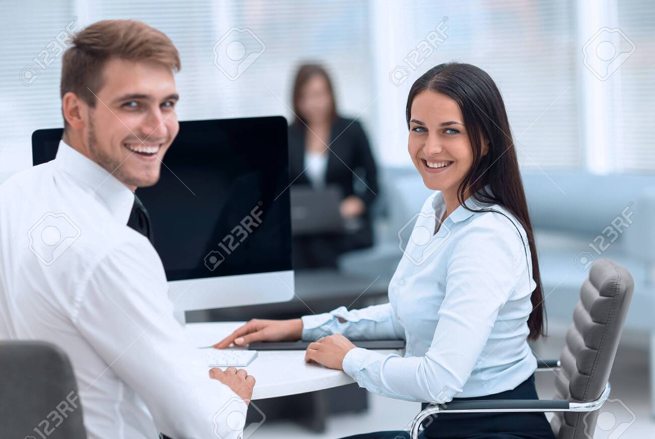 members of the business team sitting at Desk and looking at camera . - 143741253 members of the business team sitting at Desk and looking at camera . - 143741253
