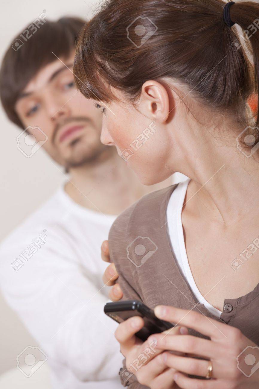 関係 興味津 々 の男から彼女の携帯電話を隠す女の秘密 の写真素材 画像素材 Image
