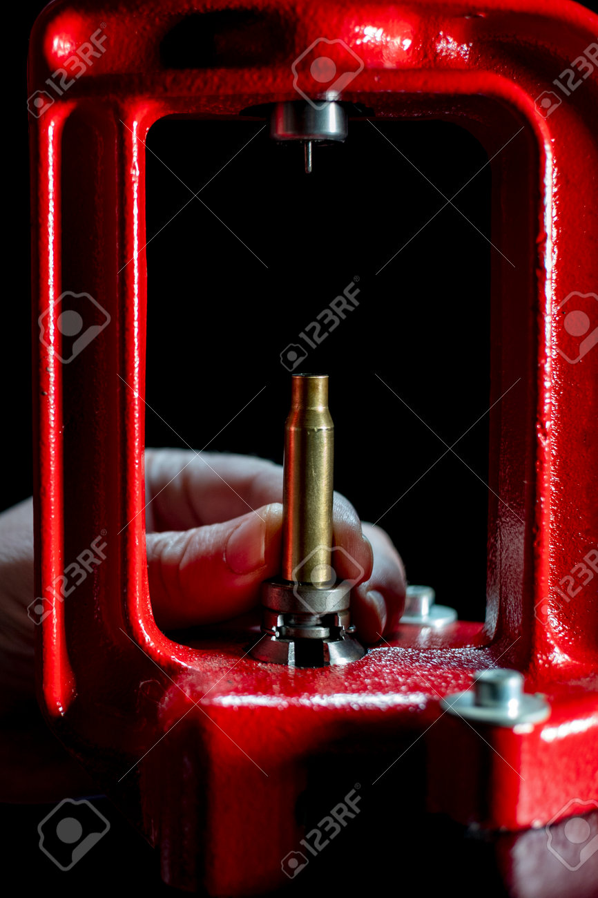 The process of making a rifle cartridge. Hand press and ammo shell against dark background, soft focus. Copy space - 162946351 The process of making a rifle cartridge. Hand press and ammo shell against dark background, soft focus. Copy space - 162946351