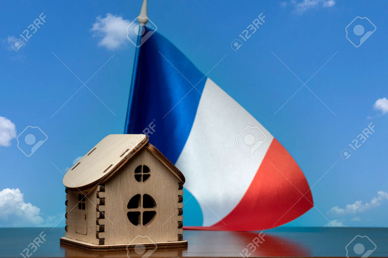 Small wooden house and France flag, sky on background. Real estate concept, copy space - 163114080 Small wooden house and France flag, sky on background. Real estate concept, copy space - 163114080