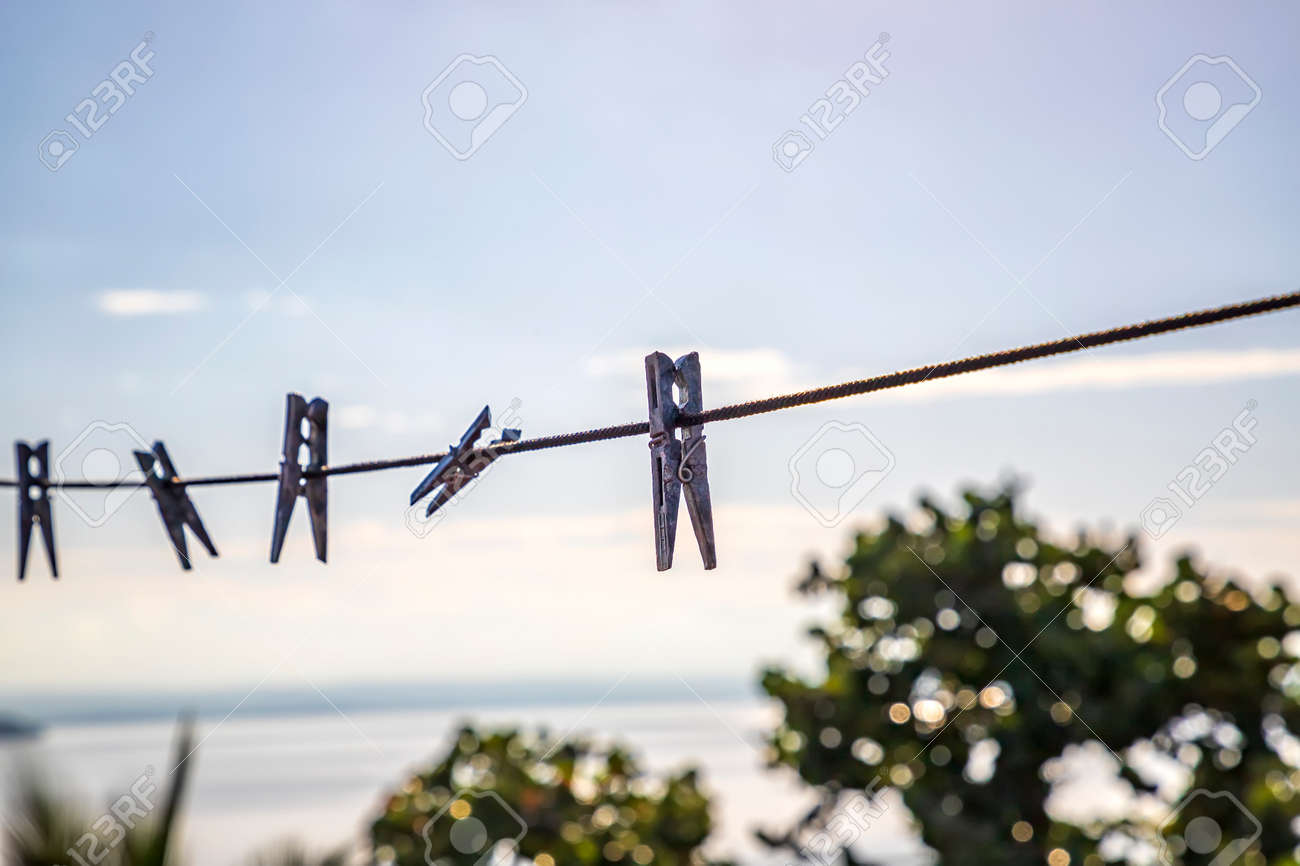 Clothespins holding clothes in laundry. clothespin on a string in a balcony. Abstract view - 164405717 Clothespins holding clothes in laundry. clothespin on a string in a balcony. Abstract view - 164405717