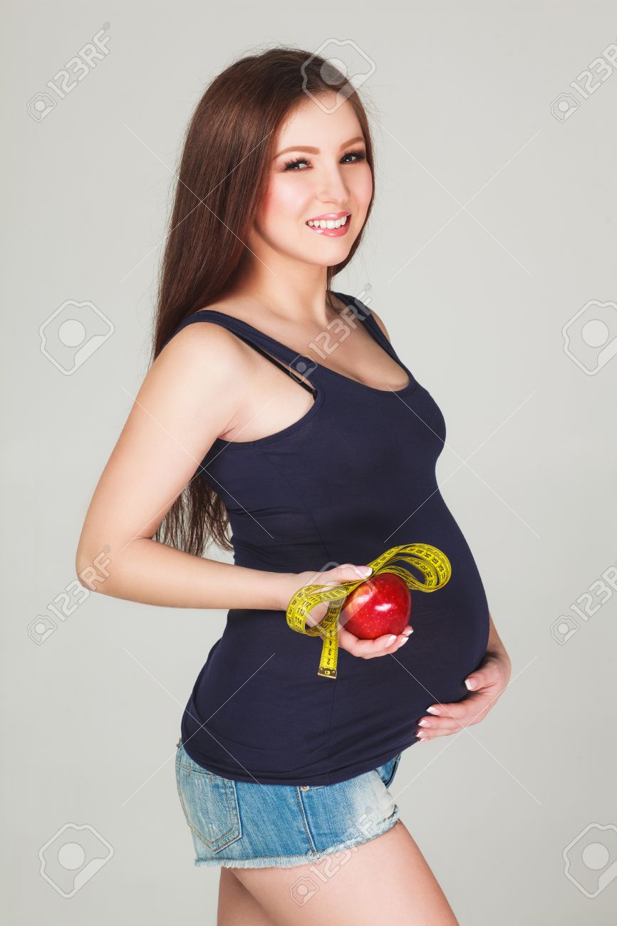 Beautiful Sexy Pregnant Woman Measuring Her Big Pregnant Belly With  Measuring Tipe And Eating Apple. Healthy Food. Pregnant Woman Tummy.  Pregnancy. Фотография, картинки, изображения и сток-фотография без роялти.  Image 38760704