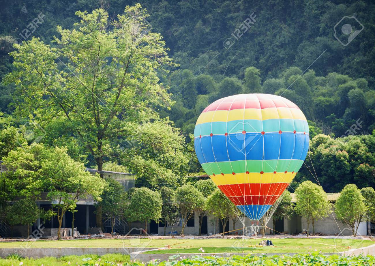 Immagini Stock La Mongolfiera Variopinta E Pronta Per Il Volo Incredibile Paesaggio Estivo Con Mongolfiera Sul Prato Inglese Accanto Alla Montagna Boscosa Image