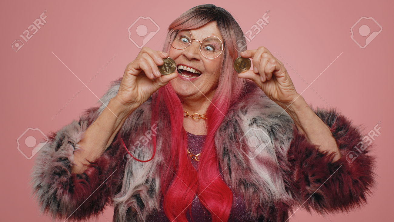 황금 비트코인 BTC 경력 부 암호화폐 투자 채굴 미래 기술 할머니를 보여주는 노인 여성 우승자는 분홍색 배경에서 행복한 사업가에게  얼굴을 속이는 모습을 보여줍니다. 로열티 무료 사진, 그림, 이미지 그리고 스톡포토그래피. Image 191638863