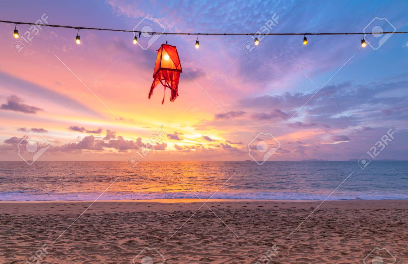 The red beach lantern lamp is hanging on cable with lightbulb