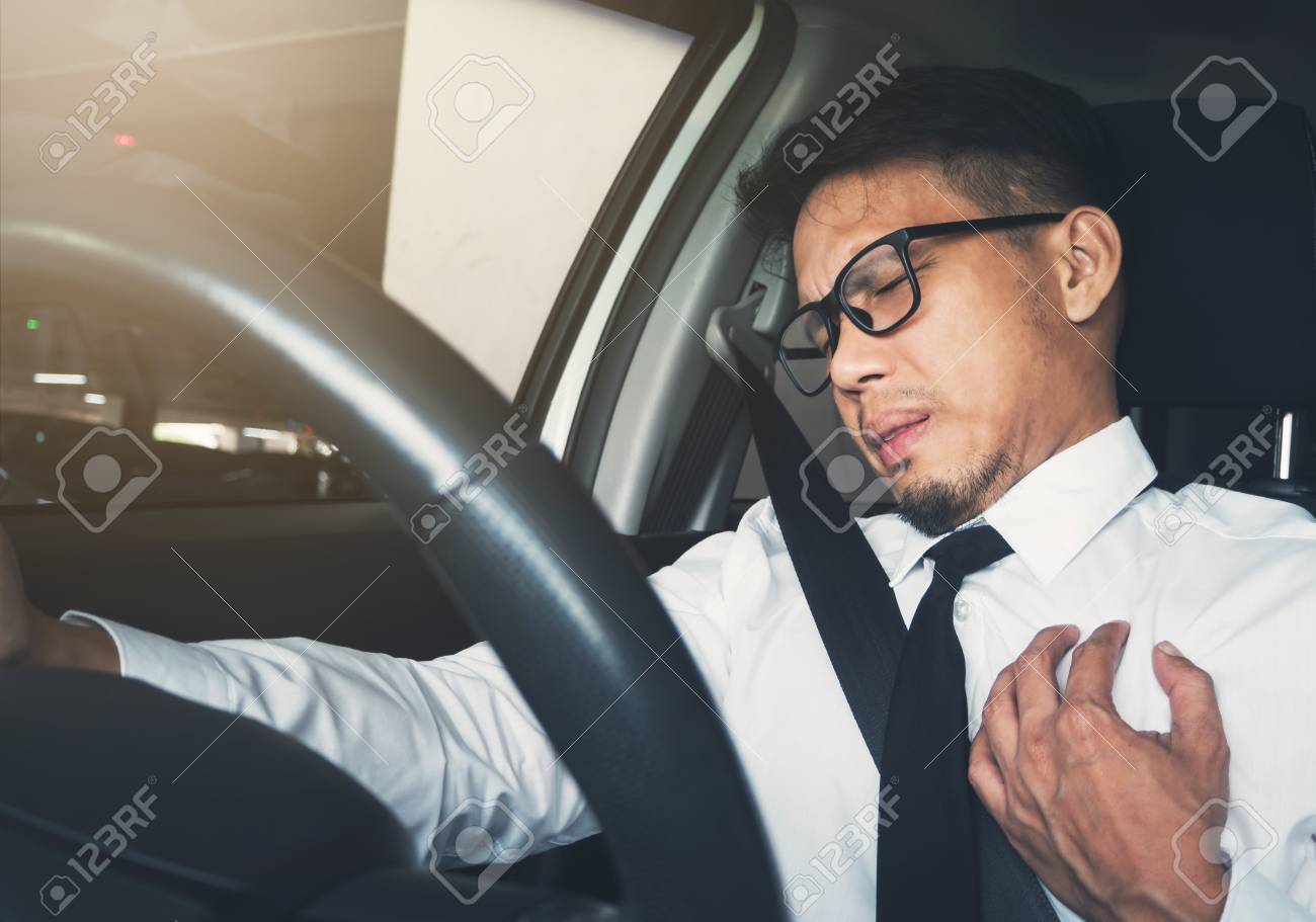 病気 疲れ 病気 過労のコンセプトの疲れています アジア系のビジネスマンは 彼の車を運転中に心臓発作を持っていること の写真素材 画像素材 Image