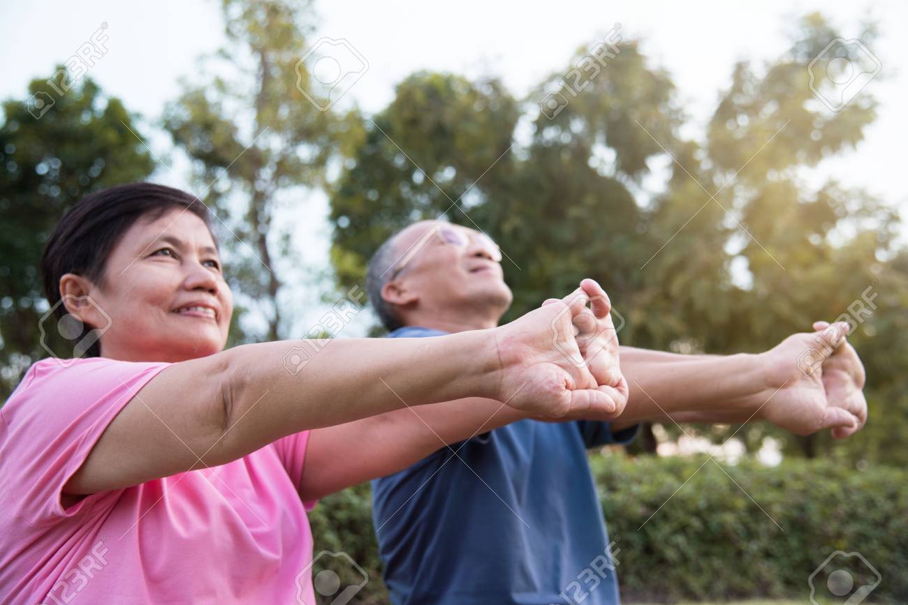 幸せなアジアのシニアのカップルは屋外の公園での運動の前にストレッチします の写真素材 画像素材 Image
