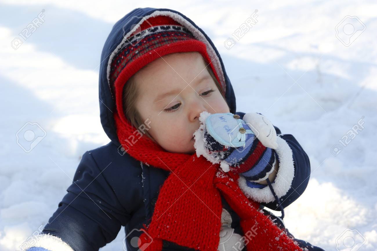 A Cute Baby Eating Snow Stock Photo Picture And Royalty Free Image