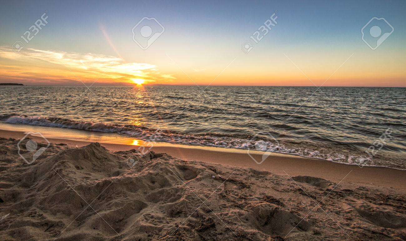 夏のサンセットビーチの背景 地平線に夕日を背景に広い砂浜に沿って夕日 ミシガン州ポート オースティン の写真素材 画像素材 Image