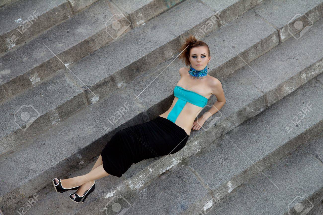 階段の上に横たわるファッションの服の未来的な若い女性 の写真素材 画像素材 Image