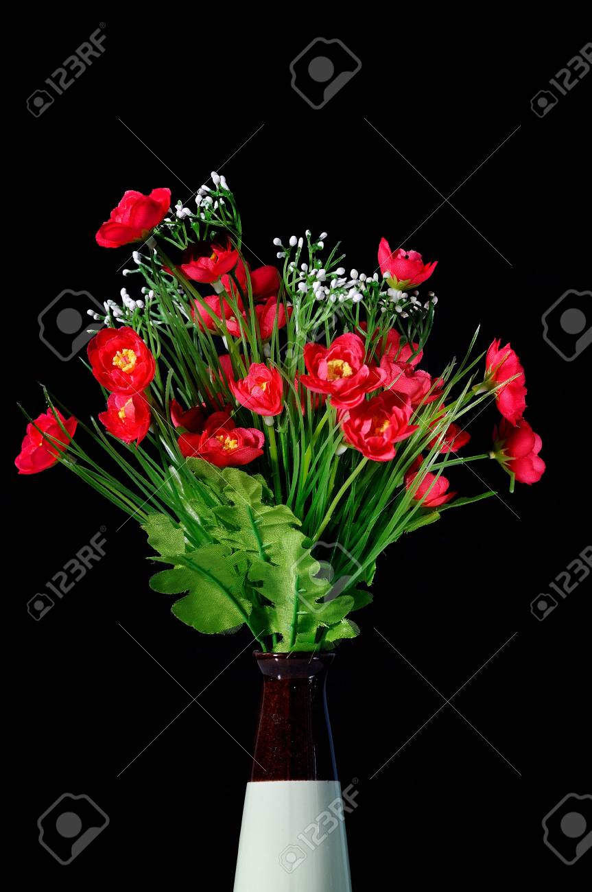 Artificial Red Flowers In Vase On Black Background Stock Photo