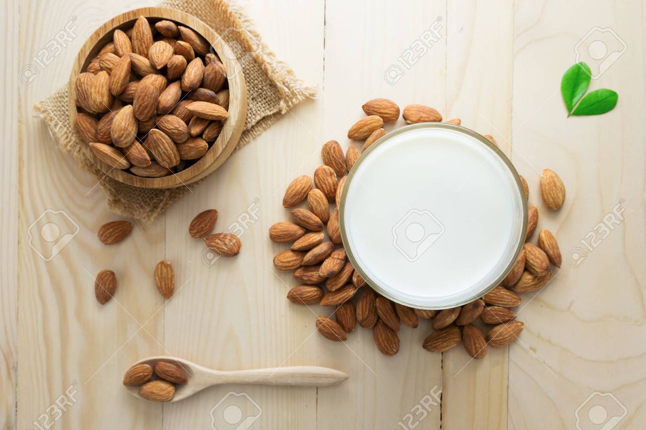 Almond milk in a glass with almonds. - 57564982 Almond milk in a glass with almonds. - 57564982