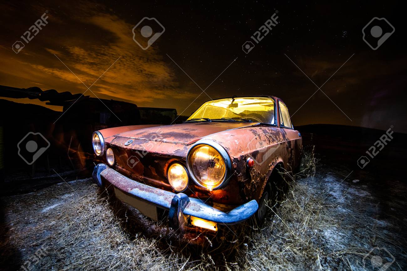 Ancient car abandoned in the countryside and illuminated with lanterns - 109412156 Ancient car abandoned in the countryside and illuminated with lanterns - 109412156