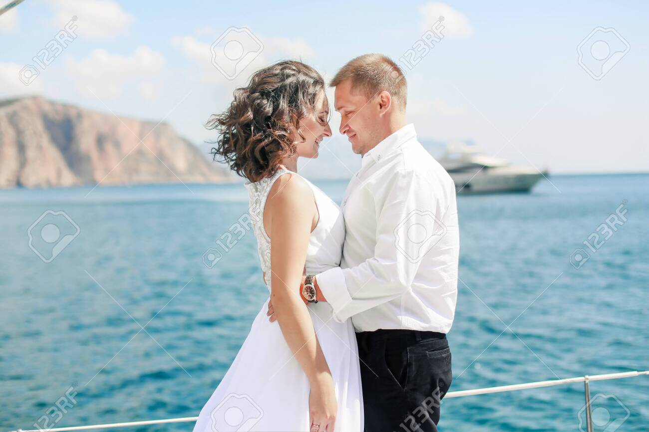 A Just married couple on yacht. Happy bride and groom on their wedding day. - 121738302 A Just married couple on yacht. Happy bride and groom on their wedding day. - 121738302