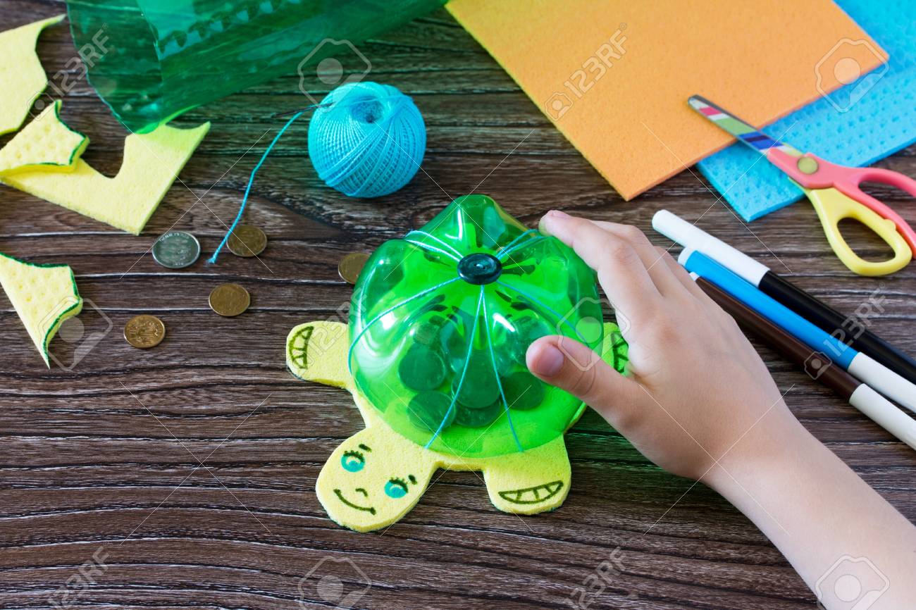 The Child Holds A Childrens Hand Craft From Plastic Bottle The Child Holds A Childrens Hand Craft From Plastic Bottle