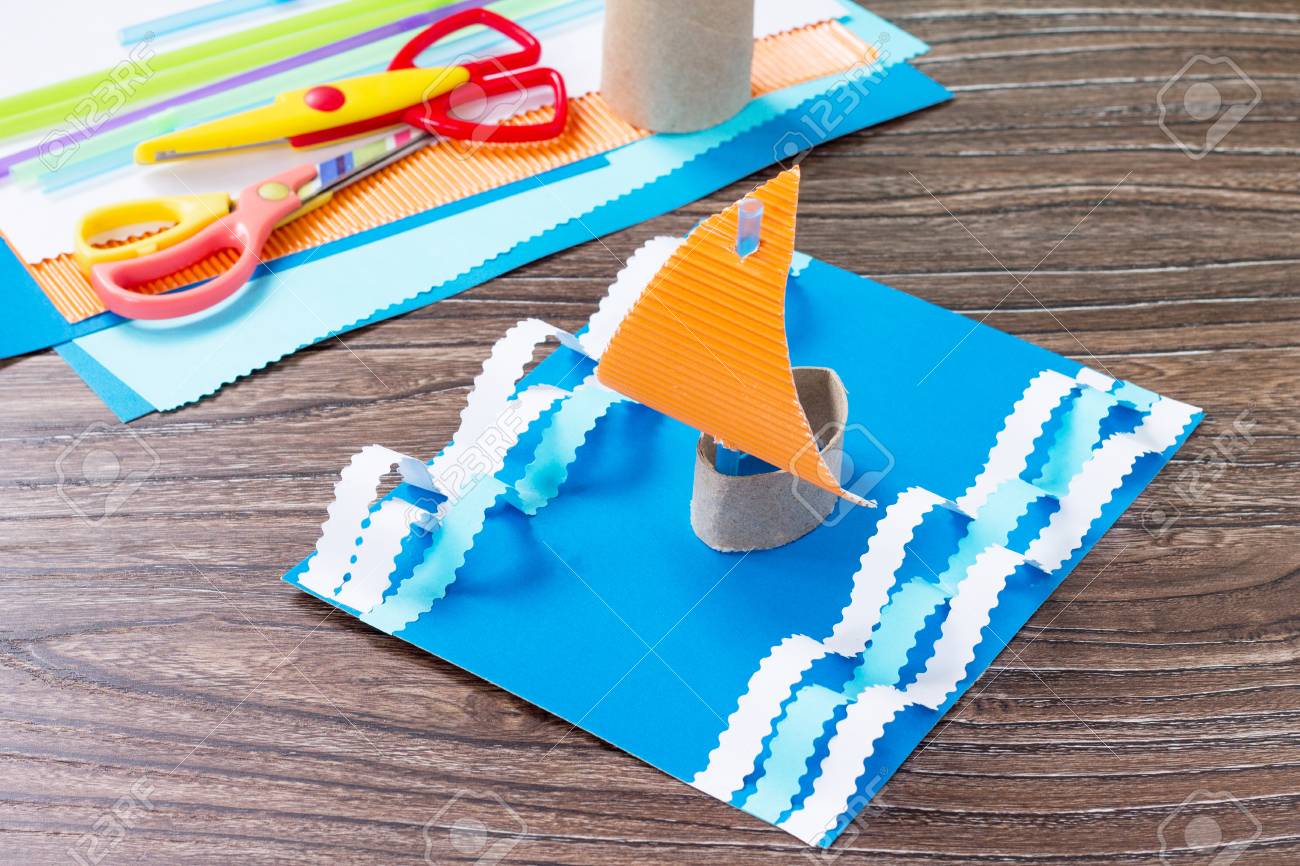 クラフトペーパーボート 父の日のお祝いのコンセプト 木製のテーブルの上に接着剤 はさみ 紙 ヒトデ 貝殻 子供のための子供のアートプロジェクトクラフト 子供のためのクラフト の写真素材 画像素材 Image