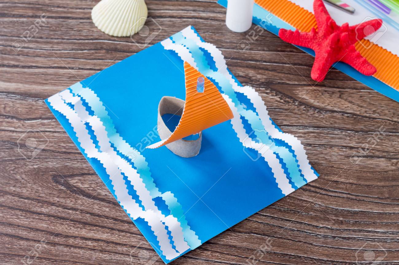 クラフトペーパーボート 父の日のお祝いのコンセプト 木製のテーブルの上に接着剤 はさみ 紙 ヒトデ 貝殻 子供のための子供のアートプロジェクトクラフト 子供のためのクラフト の写真素材 画像素材 Image