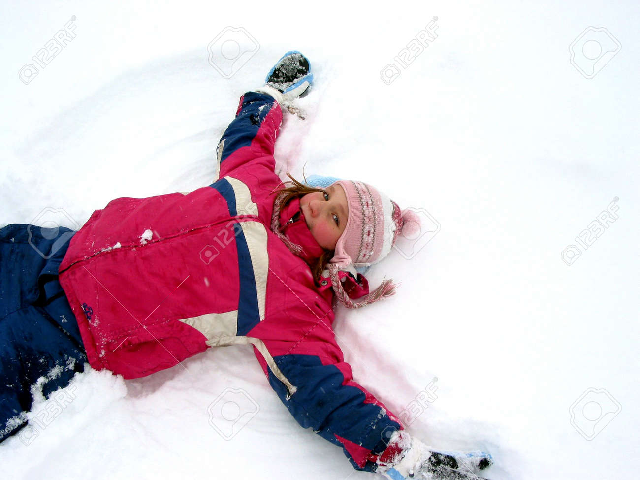新鮮な白い雪で雪の天使を作る若い女の子 の写真素材 画像素材 Image