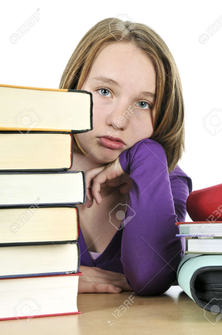 Frustrated teenage girl studying at the desk with big stack of books - 4015636 Frustrated teenage girl studying at the desk with big stack of books - 4015636