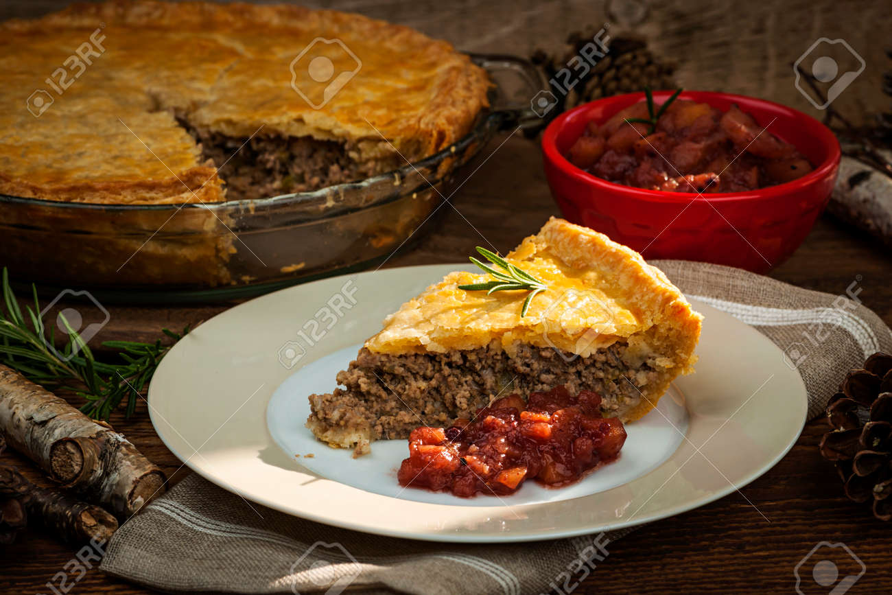 Slice of traditional pork meat pie Tourtiere with apple and cranberry chutney from Quebec, Canada. - 27340416 Slice of traditional pork meat pie Tourtiere with apple and cranberry chutney from Quebec, Canada. - 27340416