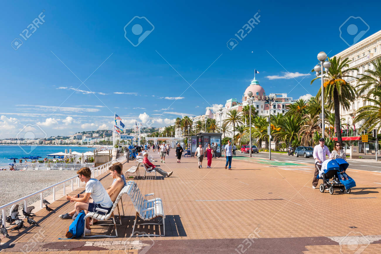 NICE, FRANCE - OCTOBER 2, 2014: People enjoying sunny weather and view of Mediterranean sea at English promenade (Promenade des Anglais), a great place for walking, jogging, biking or simply relaxing. - 37990291 NICE, FRANCE - OCTOBER 2, 2014: People enjoying sunny weather and view of Mediterranean sea at English promenade (Promenade des Anglais), a great place for walking, jogging, biking or simply relaxing. - 37990291