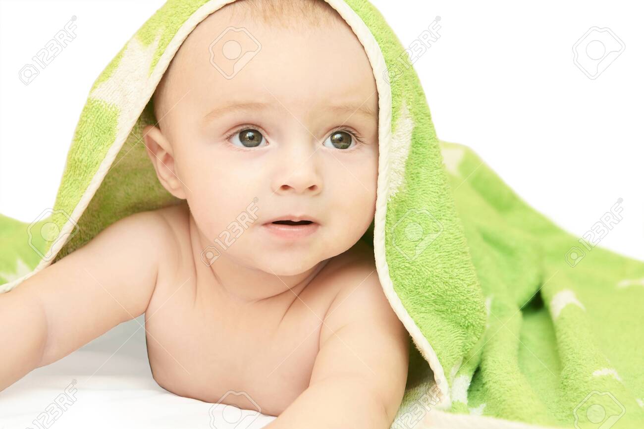 Cute little baby. Under bath towel. Happy kid portrait. White background. Lying at home bed. Infant playing. Beautiful bear. New human. Face skin care. Good emotion. Look side. - 152514739 Cute little baby. Under bath towel. Happy kid portrait. White background. Lying at home bed. Infant playing. Beautiful bear. New human. Face skin care. Good emotion. Look side. - 152514739