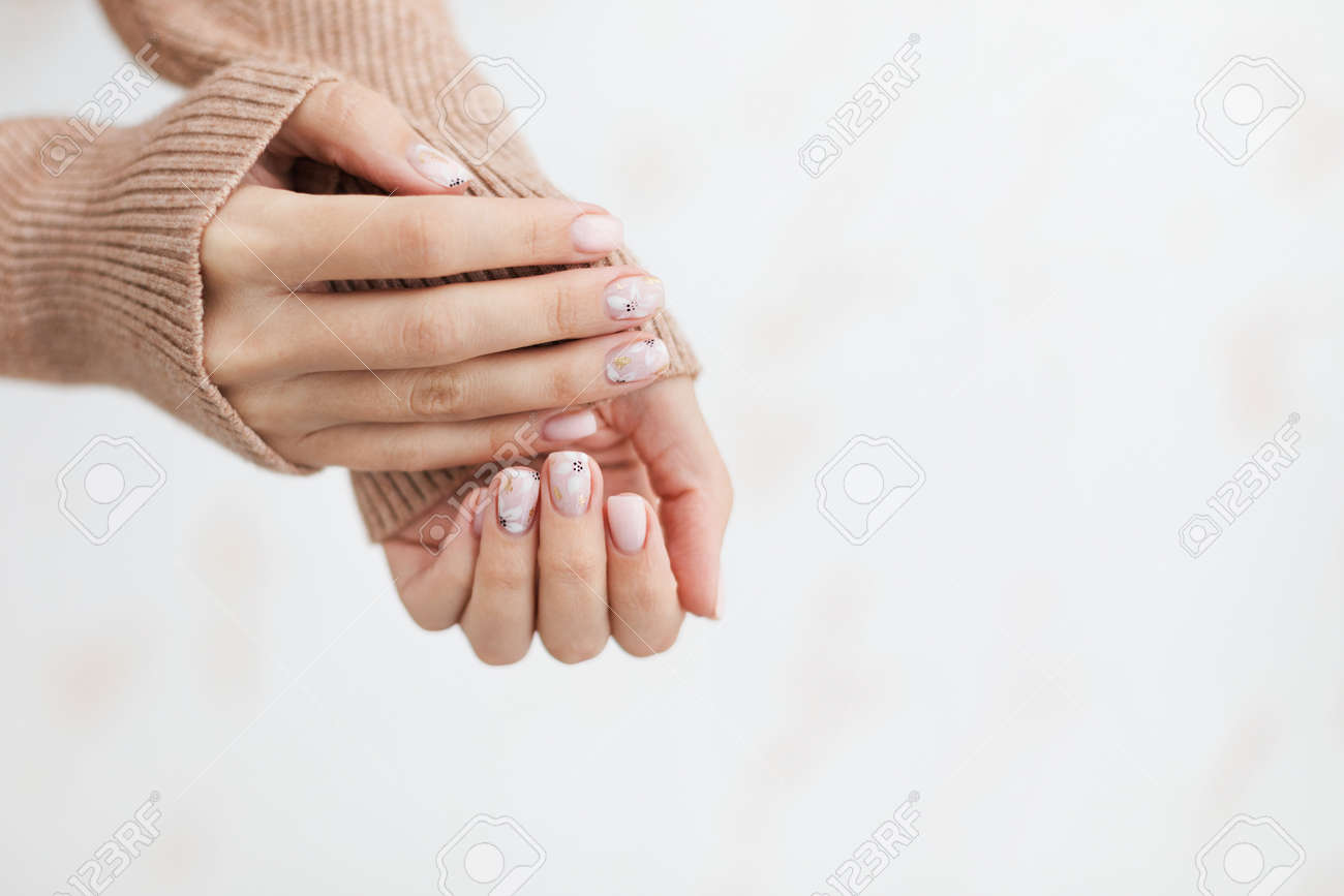 Female hand manicure close up view with warm sweater on light background. - 163588272 Female hand manicure close up view with warm sweater on light background. - 163588272