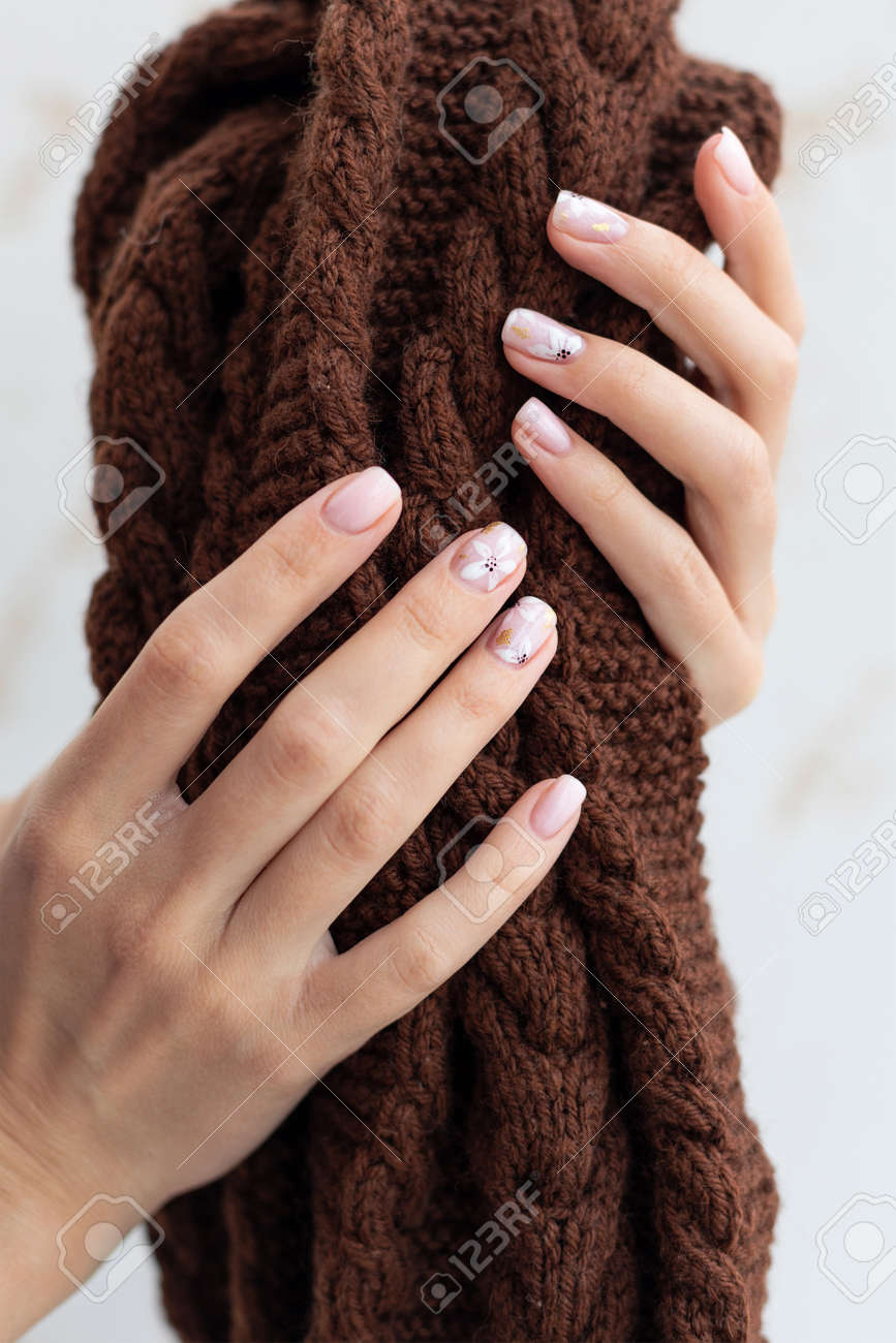Female hand manicure close up view with warm sweater on light background. - 163588262 Female hand manicure close up view with warm sweater on light background. - 163588262
