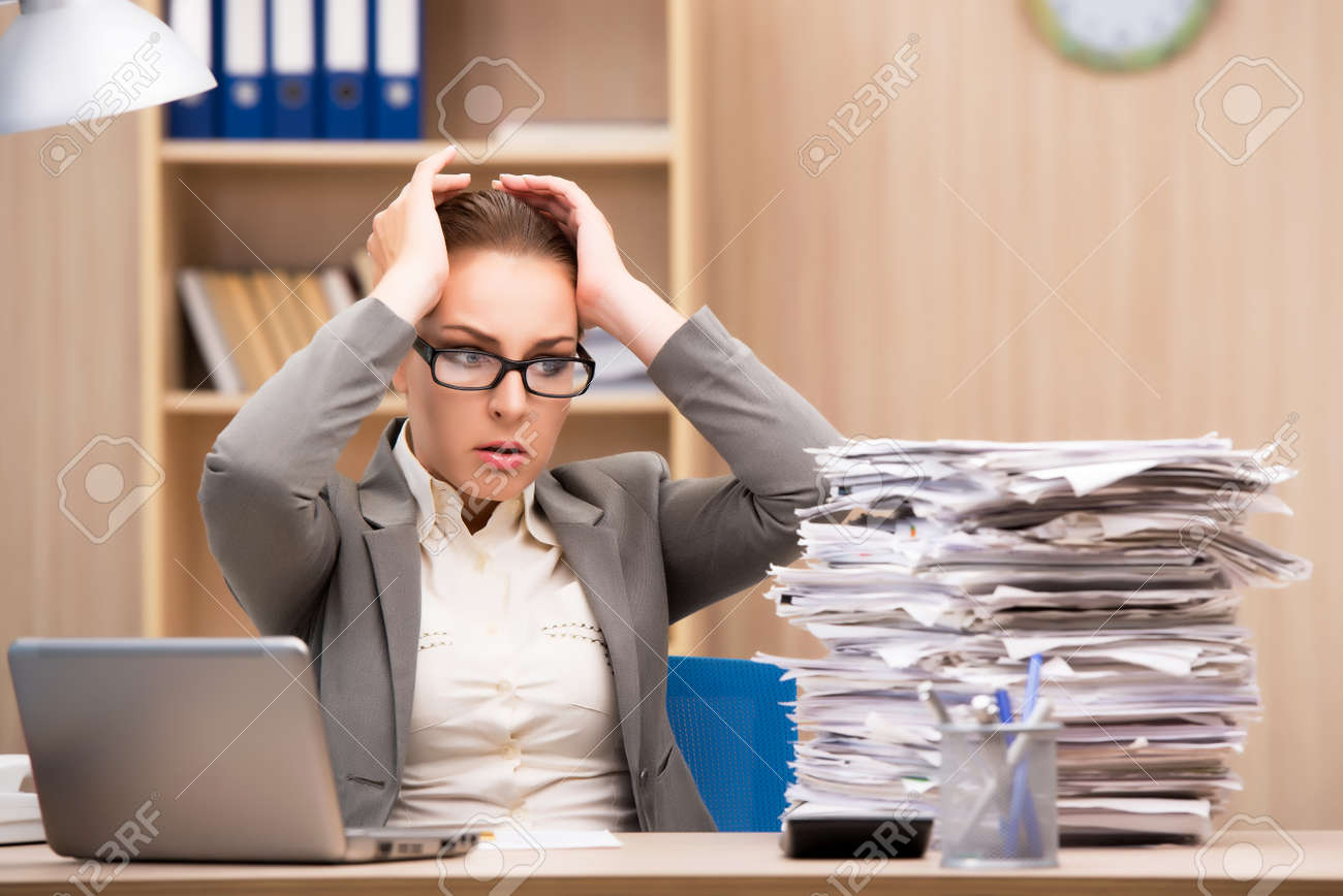 businesswoman under stress from too much work in the office stock too much work