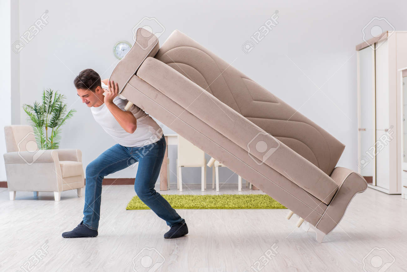 Man moving furniture at home - 67522834 Man moving furniture at home - 67522834