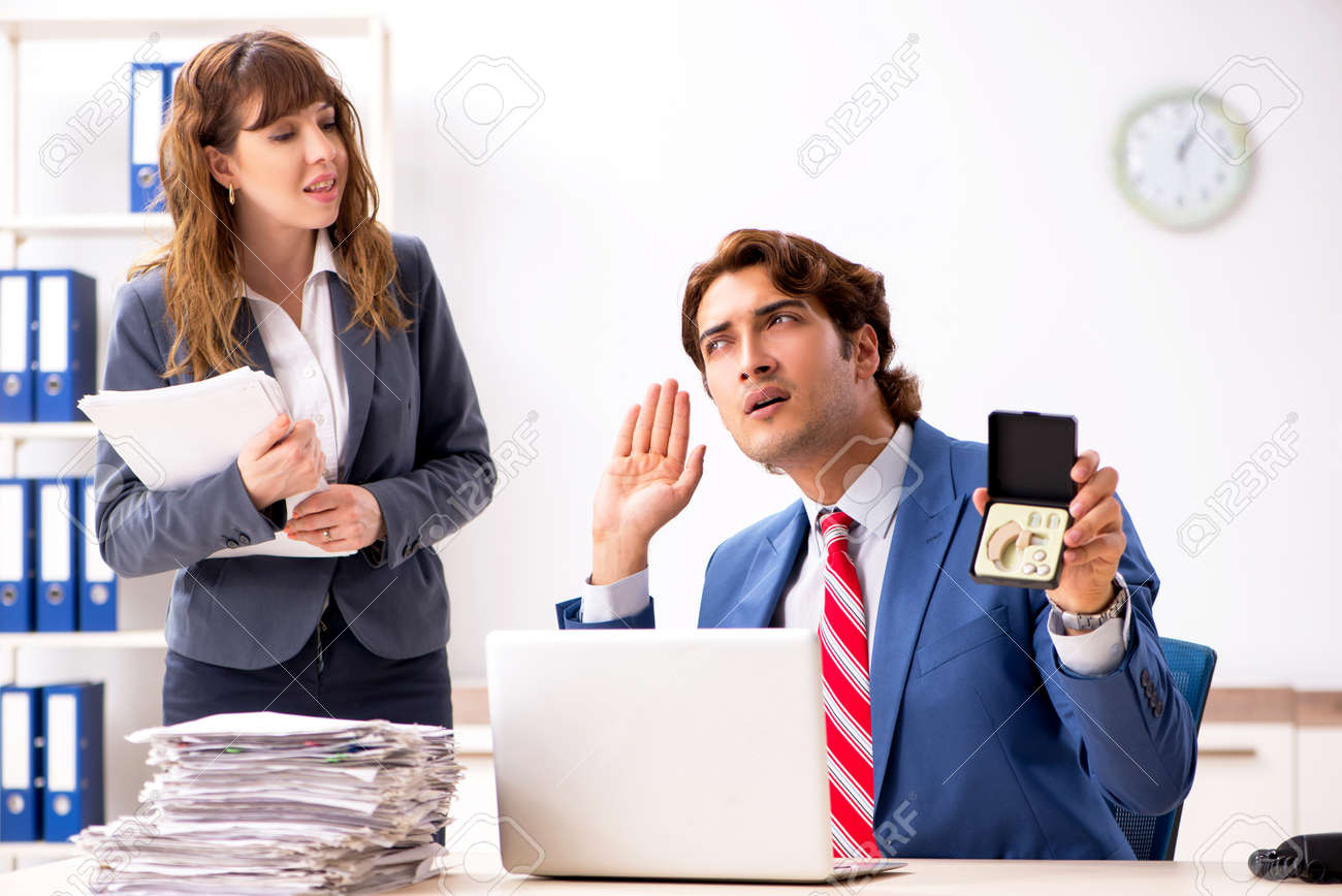 deaf employee using hearing aid talking to boss employment for the deaf