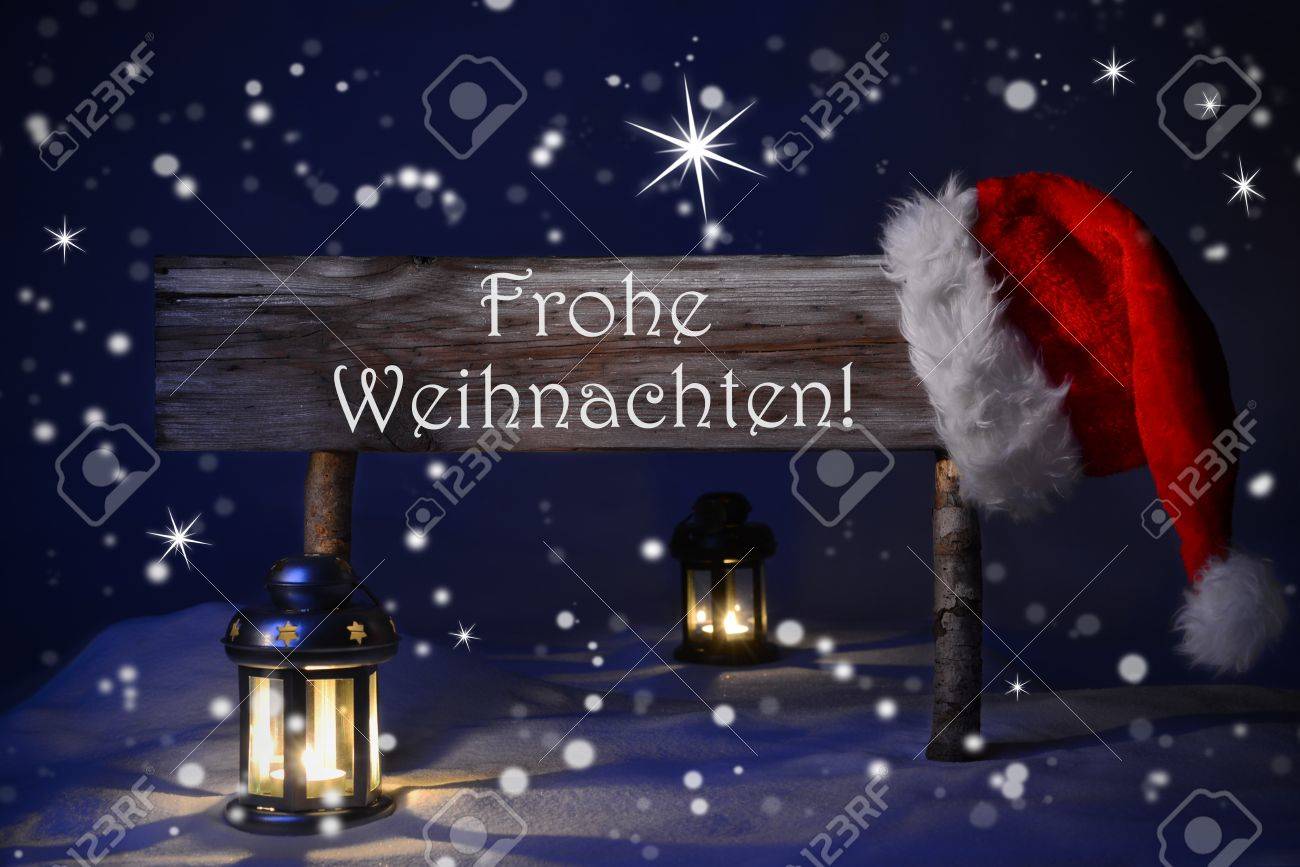 木製のクリスマス サインと雪とサンタ帽子 ドイツ語のテキスト Fohe アドベントは 季節のご挨拶のためメリー クリスマスを意味します 雪やきらめく星と青い静かな夜 ランタンとキャンドル ライト の写真素材 画像素材 Image