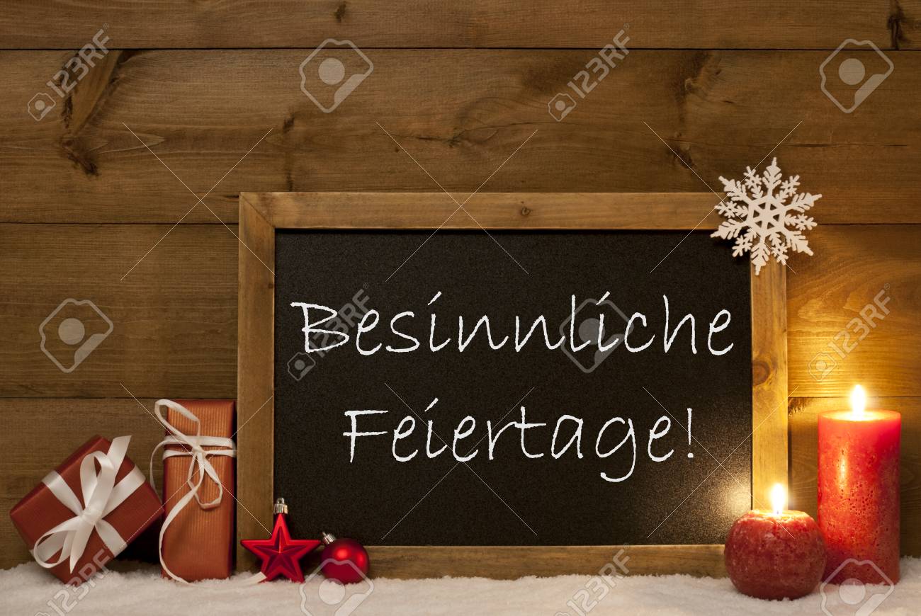 黒板 赤の贈り物 クリスマス ボール スノーフレークやキャンドルでお祝いクリスマス カード ヴィンテージの木製の背景を持つクリスマスの装飾 メリー クリスマスを意味するドイツ語のテキスト Besinnliche Feiertage の写真素材 画像素材 Image