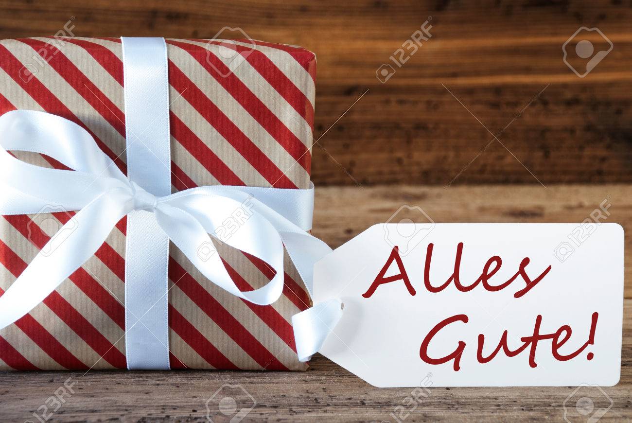 クリスマス ギフトの木製の背景に存在するマクロ 季節のご挨拶 ご多幸をお祝いのカード 弓でホワイト リボン ドイツ語のテキスト Alles Gute 意味の最高の願い の写真素材 画像素材 Image