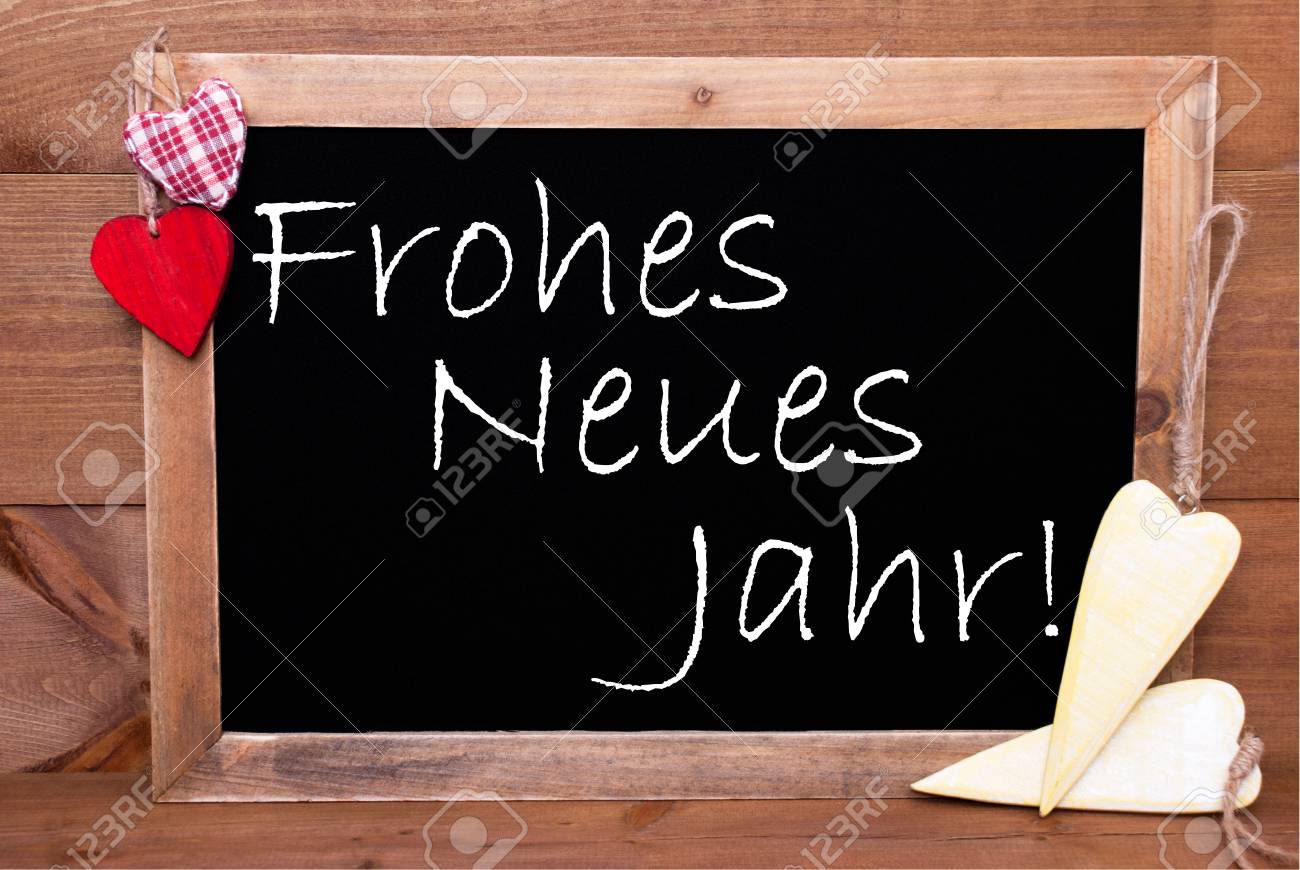 ドイツ語のテキスト Frohes ノイエス ヤールと黒板は 幸せな新年を意味します 赤い織物と木製の黄色いハート 素朴なヴィンテージやレトロなスタイルの木製の背景 の写真素材 画像素材 Image