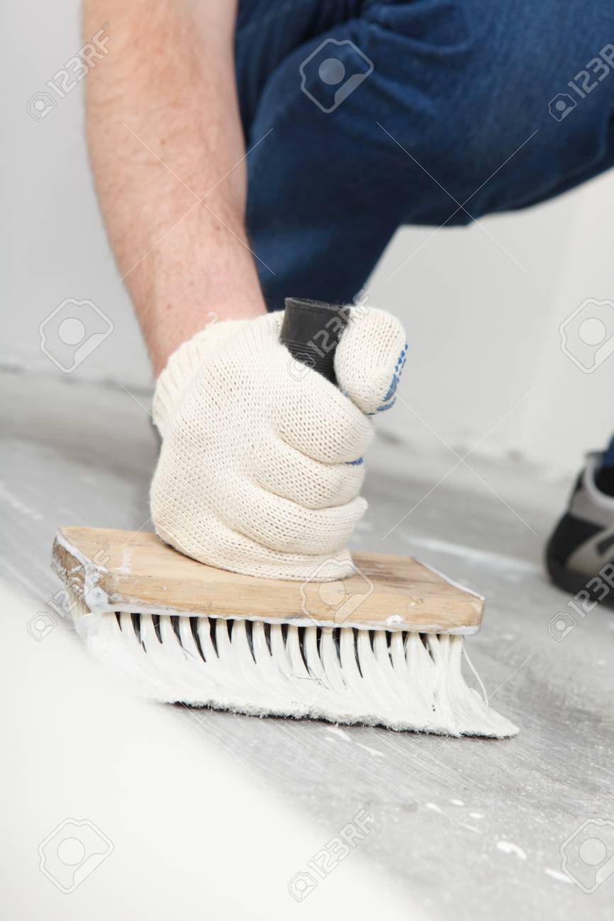 Man Puts Glue For A Linoleum Flooring Stock Photo Picture And