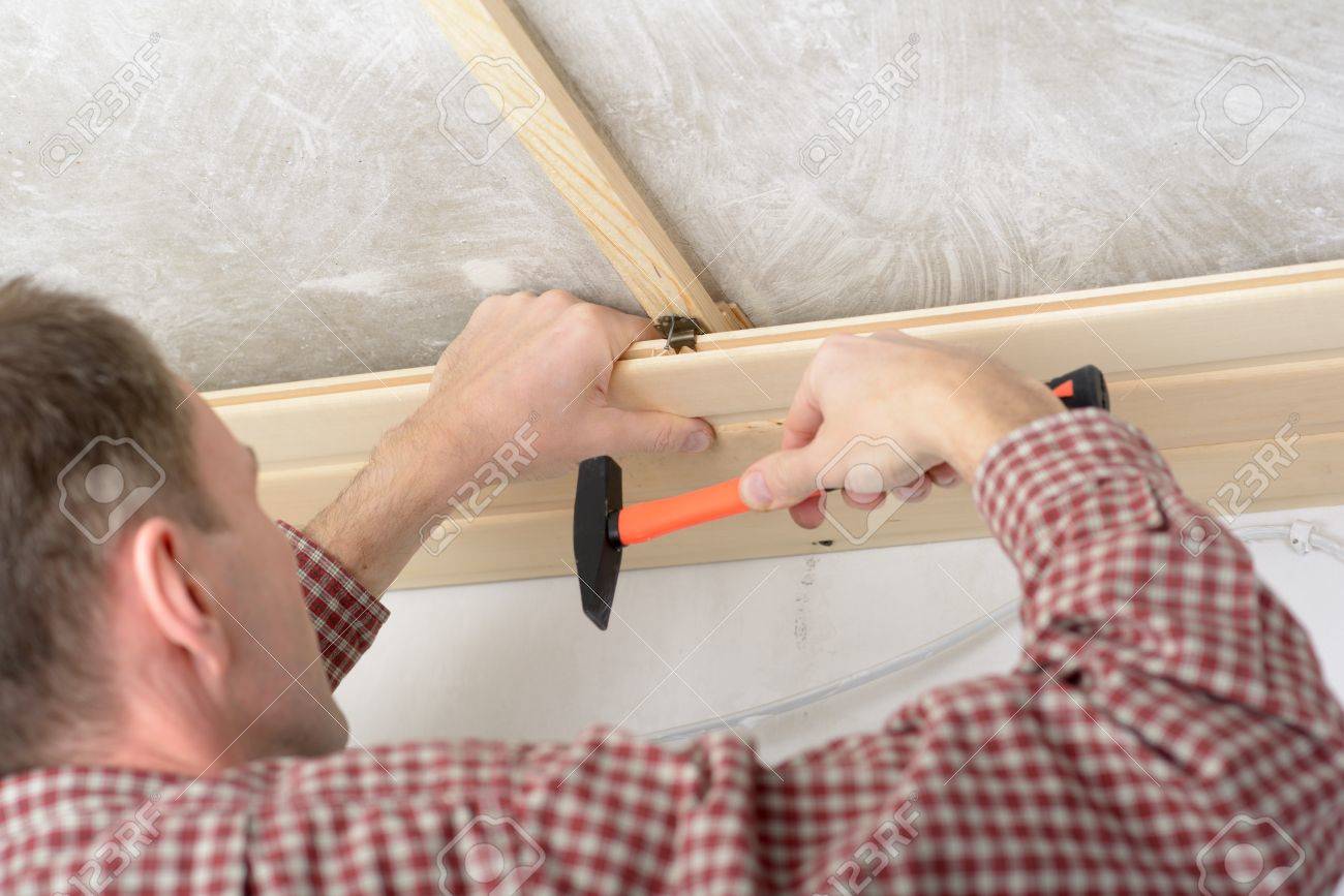 Contractor Installing Wood Panels On A Ceiling Stock Photo