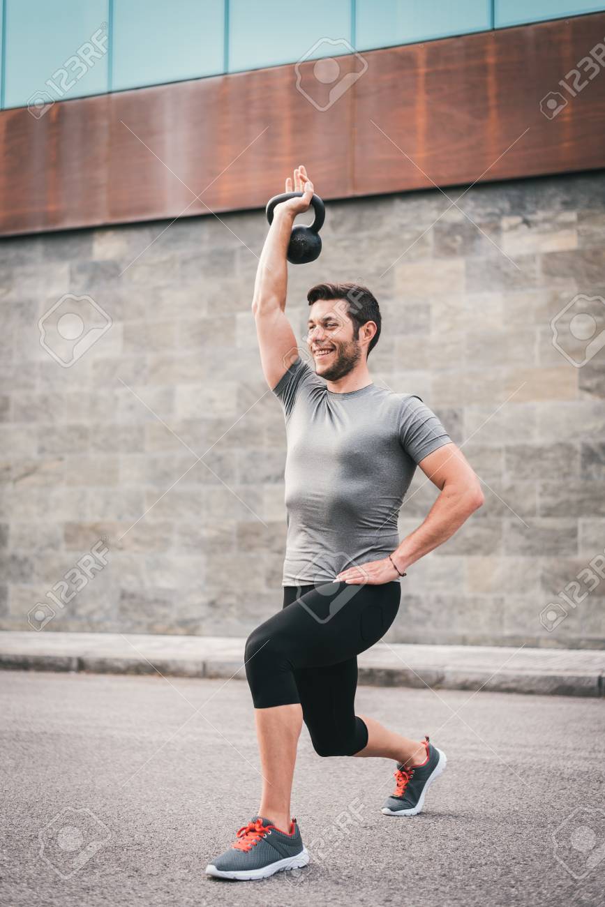 Homme Sporty Exercice Avec Kettlebell Sur Lentraînement En Plein Air Urbain Fitness Homme Souriant Travaillant à Lextérieur - 