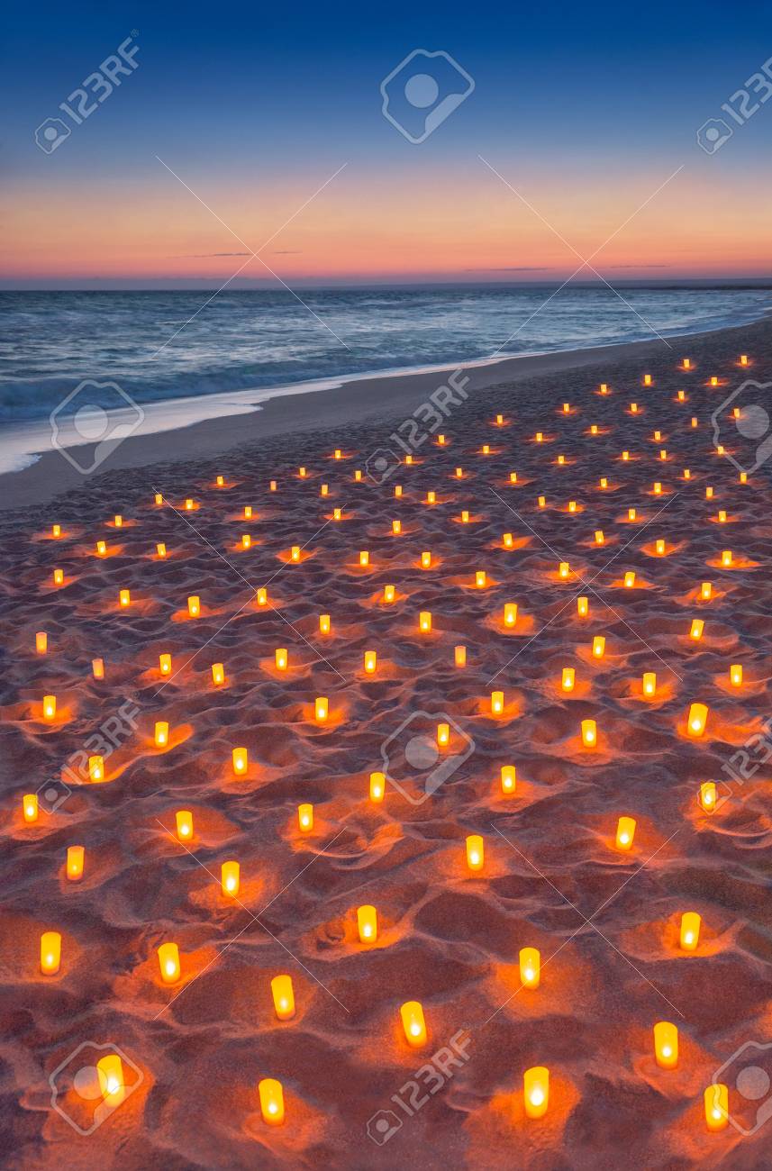 sunset ocean sandy beach decorated with lot flare lights of candles