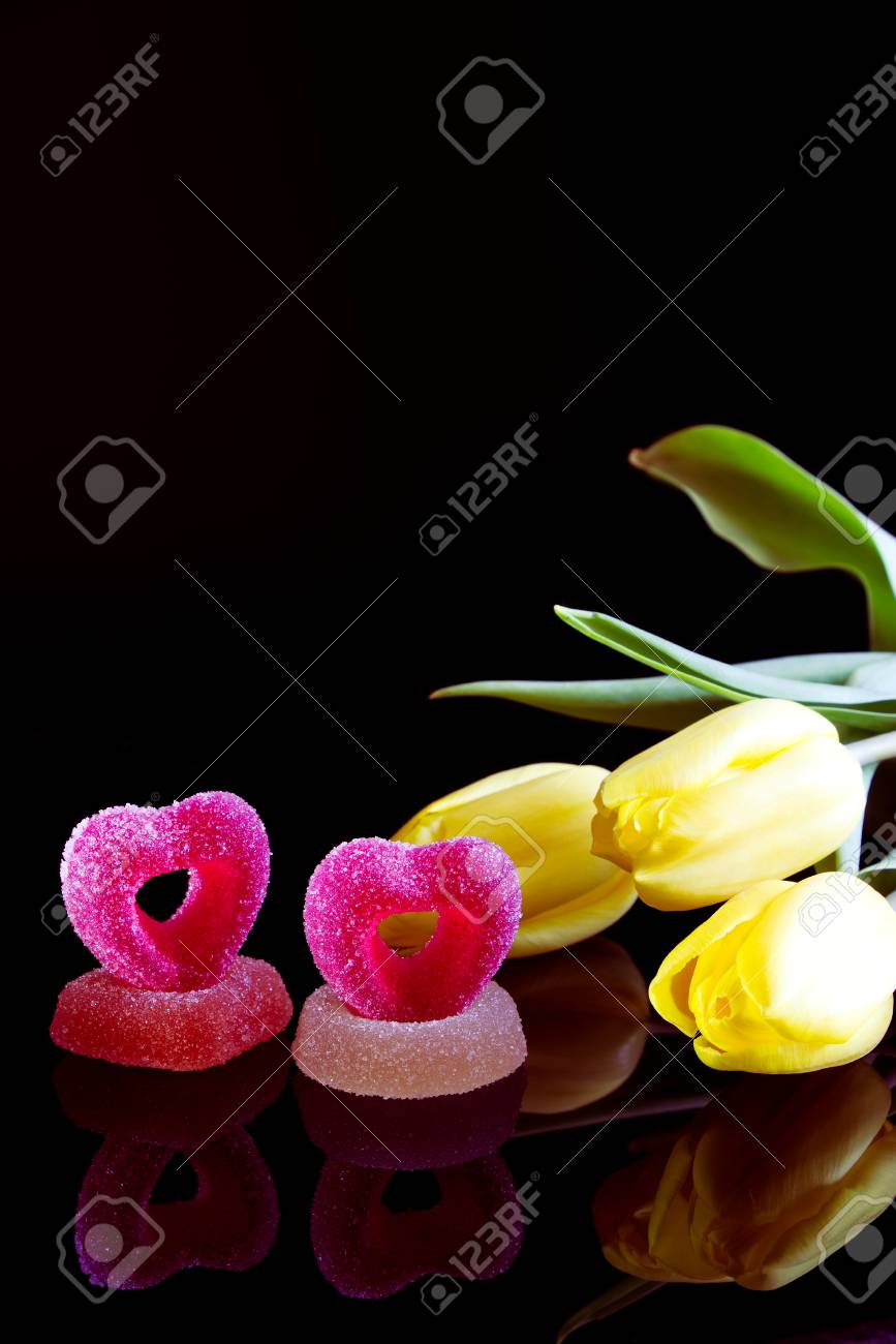 ロマンチックな砂糖菓子と黄色のチューリップ 黒い背景にギフトとして花とゼリー菓子のブーケ の写真素材 画像素材 Image