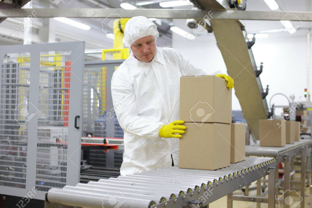 caucasian worker in white apron at packing line in factory - 29391876 caucasian worker in white apron at packing line in factory - 29391876